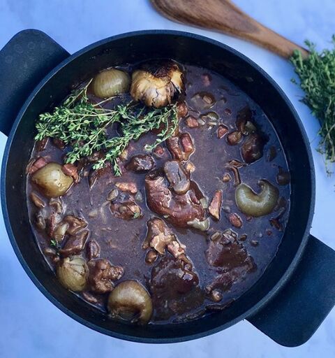 Mandy’s boeuf bourguignon in a black casserole, with baby onions, mushrooms and fresh thyme